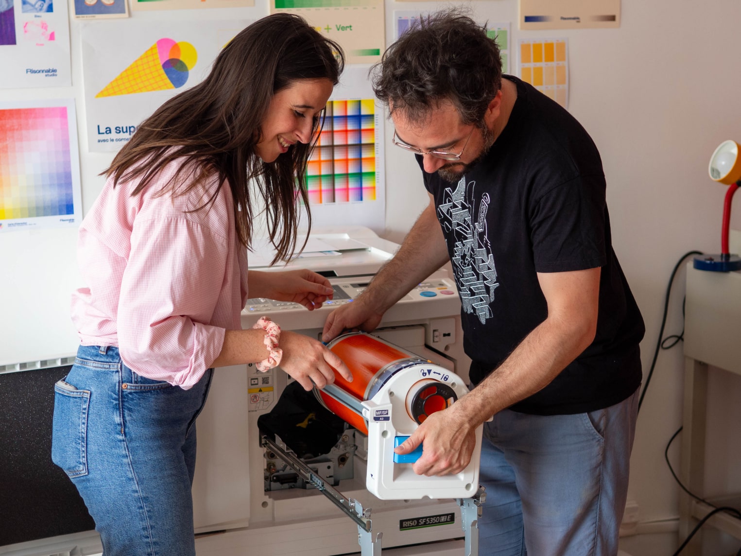 Participant d'un atelier regardant un pochoir de risographie
